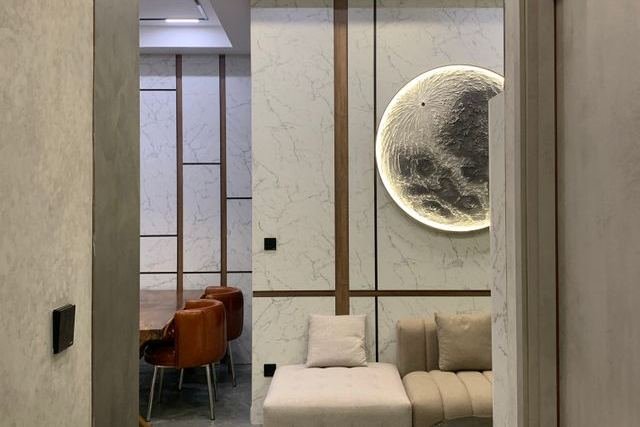 A lounge with a marble feature wall and round wall lights