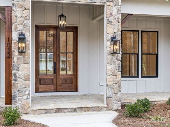 A timber front door and windows in a stone porch