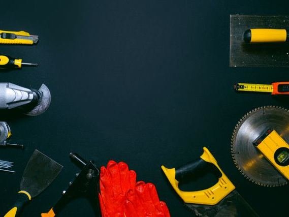 Hand tools and a saw blade laid out on a dark surface